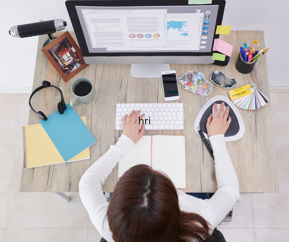 A person sitting at a desk typing on a keyboard