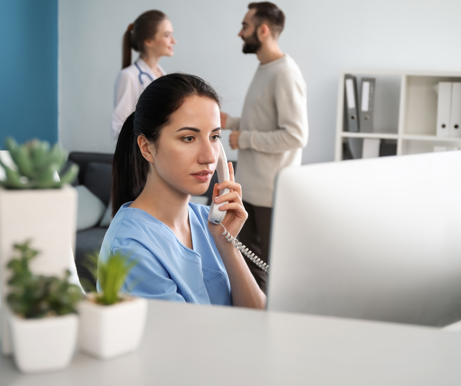 A person in blue scrubs holding a phone to her ear