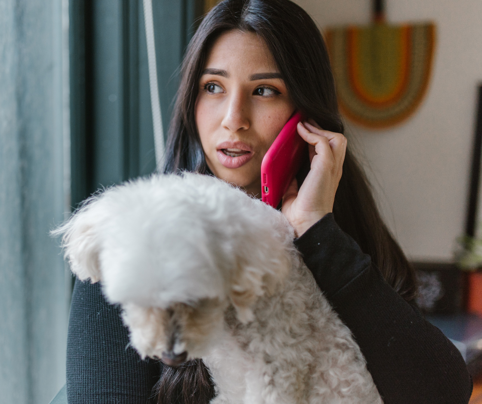 Concerned pet owner calling the veterinary clinic while holding her dog